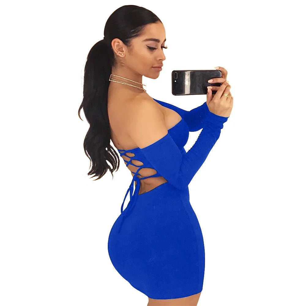 Woman in blue dress with cutouts taking selfie.
