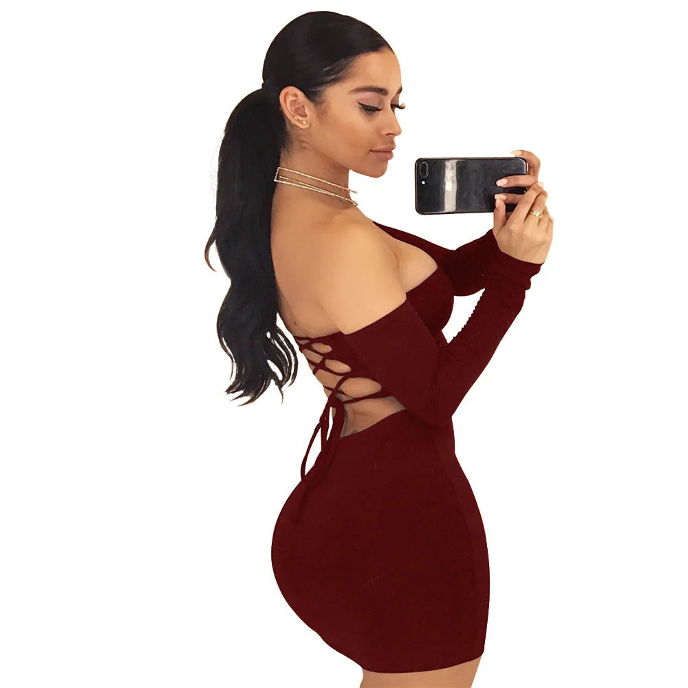 Woman in burgundy dress with lace-up detail taking a selfie.