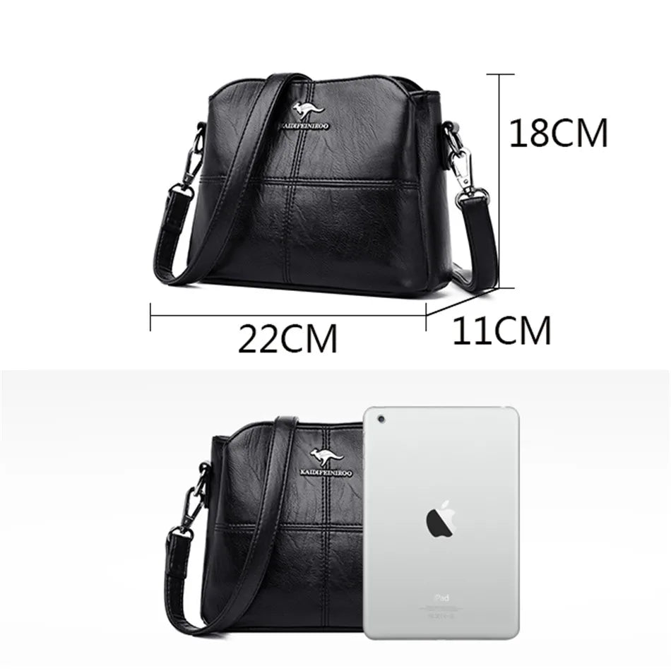 Black leather shoulder bag with kangaroo logo, 22cm x 18cm x 11cm, shown with an iPad for scale.