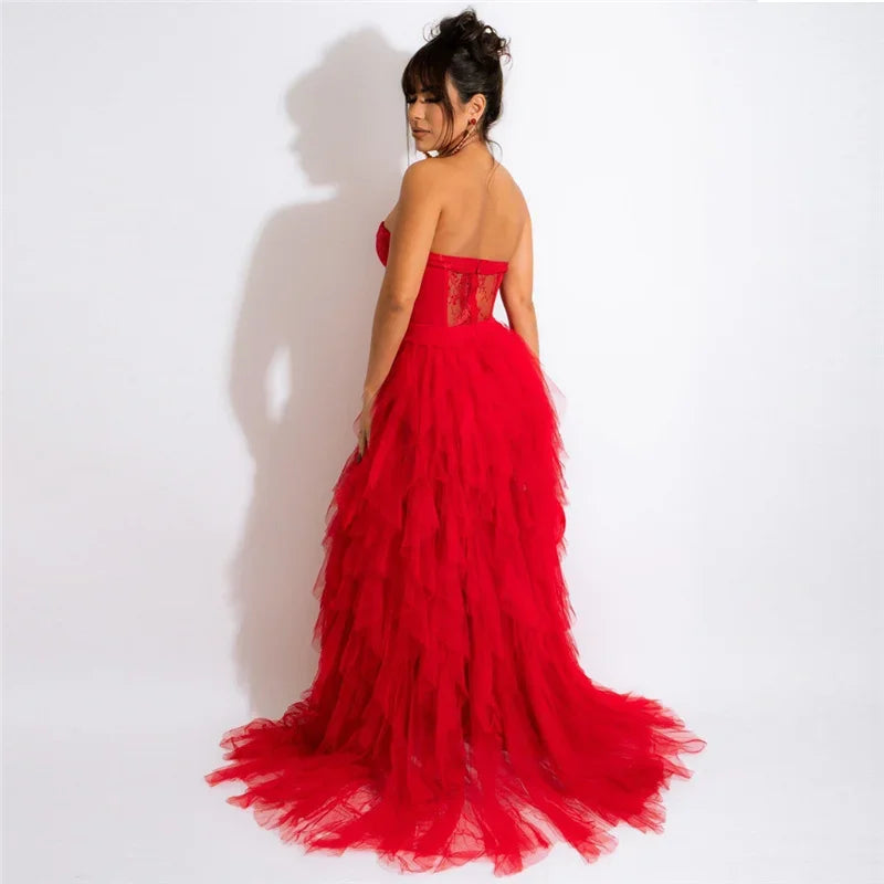 Woman wearing a red, tiered tulle gown with a high neckline.
