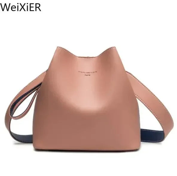Pink leather bucket bag with dual straps and a minimalist design.