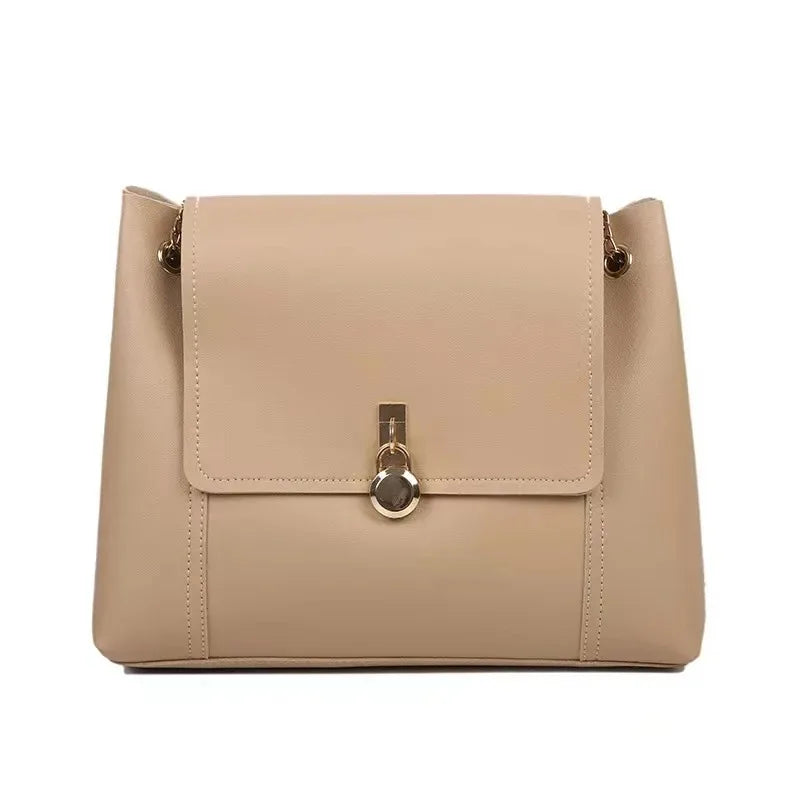 Beige leather shoulder bag with gold clasp and chain strap on white background.